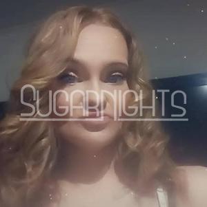 Kendall poses for a close up portrait with curled blonde hair.